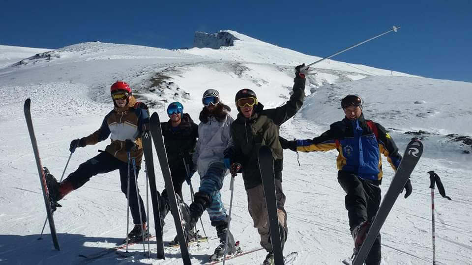 Grupo de alumnos con esquís en una cresta nevada de Sierra Nevada