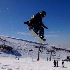 Rider de snowboard saltando sobre la nieve en Sierra Nevada