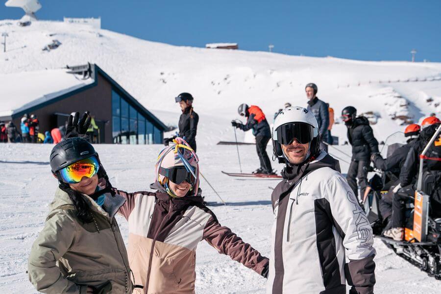 Grupo con casco y gafas de esqui junto a la estacion de Sierra Nevada